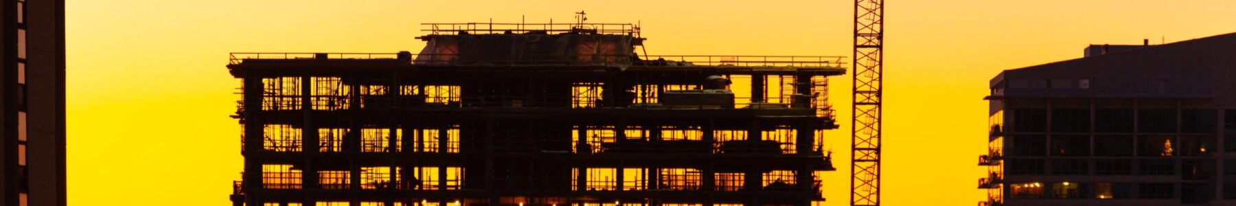 Silhouette of Crane and Building Under Construction at Dusk.